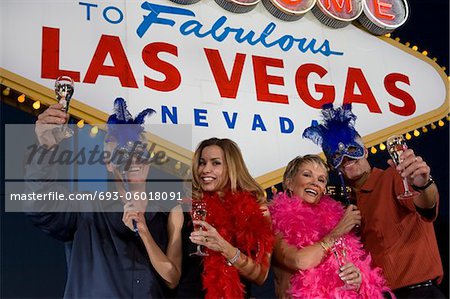 Deux femmes et deux hommes posant devant Bienvenue à Las Vegas sign, portrait de groupe