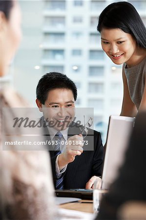 Business people using laptop in office