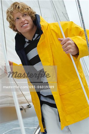 Young man standing on yacht