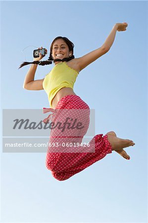 Young woman jumping with mp3 player in hand