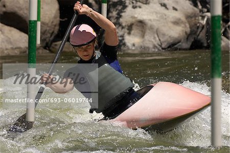 Jeune femme kayak d'eau vive