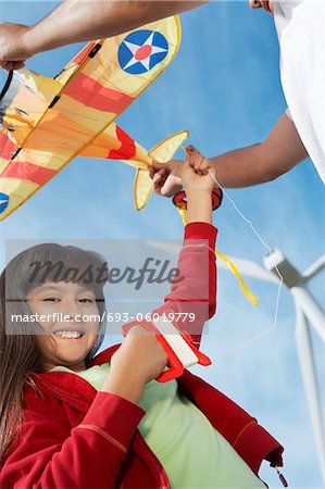 Girl (7-9) Betrieb Flugzeug kite mit Vater am Windpark