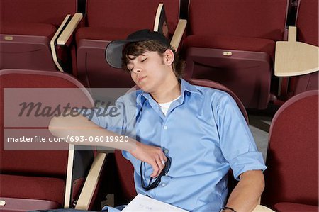 male college student sleeping in classroom