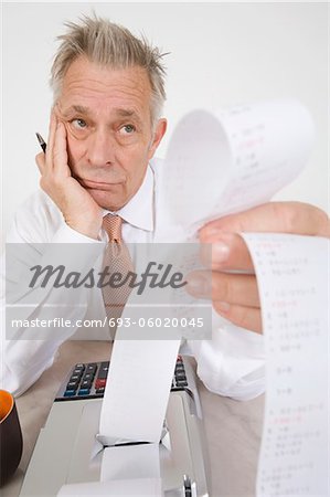 Businessman Looking at Calculator Paper