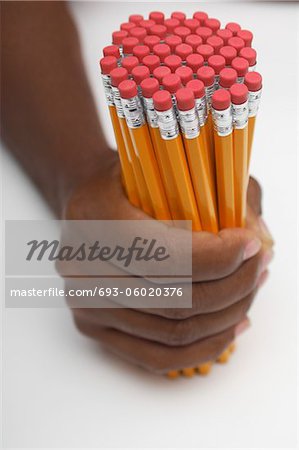 Personne qui détient un groupe important de crayons, gros plan des mains