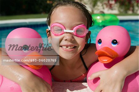Mädchen am Pool-Seite hält Rosa Gummienten