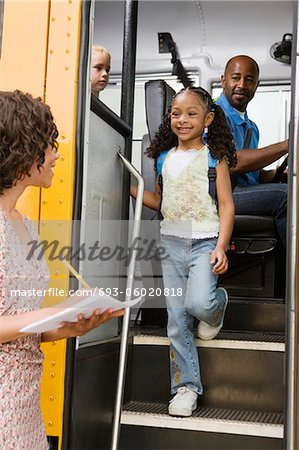 Élèves du primaire enseignant déchargement d'autobus scolaire