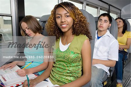Les adolescents faisant devoirs While Riding School Bus