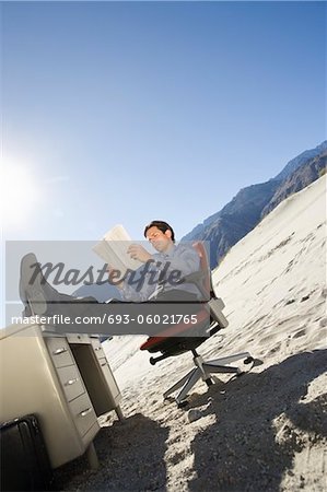 Businessman Sitting At Desk in the Desert