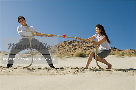 Two Business People Playing Tug of war in the Desert