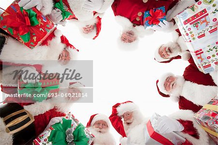 Group of men dressed as Santa Claus, looking down, low angle view