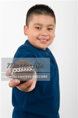 Pre-teen (10-12) boy holding out cookie