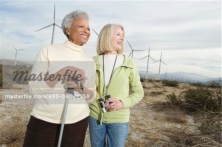 Women hiking near wind farm