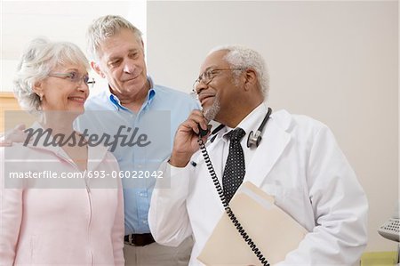 Médecin principal au téléphone avec un couple senior