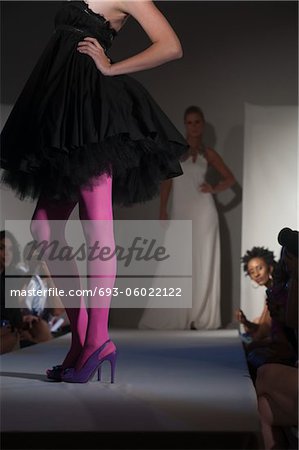 Low section of woman in pink tights and party dress on fashion catwalk