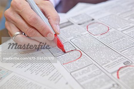 Woman circling employment ads in paper