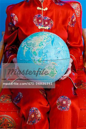 Woman in Chinese pajamas holding globe