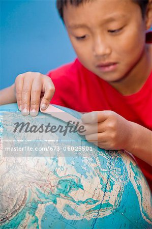 Boy placing bandaid on globe