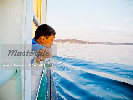 Young boy looking out ferry window