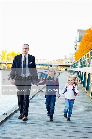 Père et enfants marchant sur la jetée