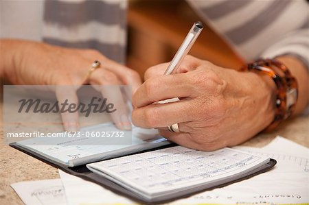 Woman writing checks in home office