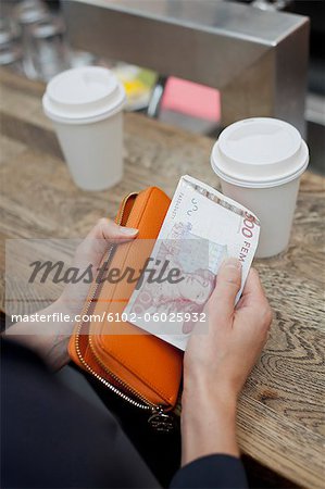 Woman holding purse and paying for coffee