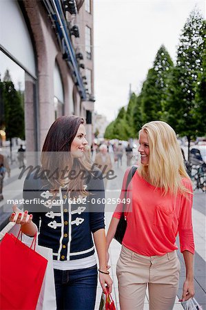 Two women with shopping bags in street
