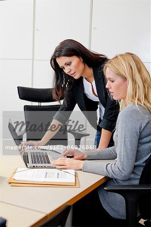 Two female colleagues working together in office environment
