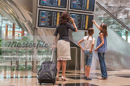Famille regardant Conseil départ arrivée à l'aéroport