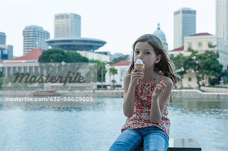 Fille manger un cornet de crème glacée de la rivière