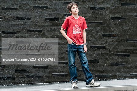 Boy listening to music with earphones, portrait