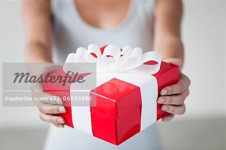 Woman holding gift box, cropped