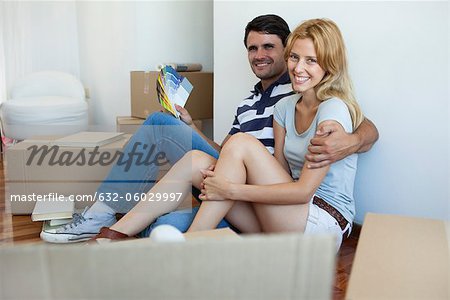 Couple unpacking in new house, man holding color swatches