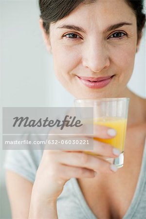 Mid-adult woman with glass of orange juice