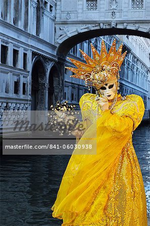 Masked figure in costume at the 2012 Carnival, with Ponte di Sospiri in the background, Venice, Veneto, Italy, Europe Masked figure in costume at the 2012 Carnival, with Ponte di Sospiri in the background, Venice, Veneto, Italy, Europe