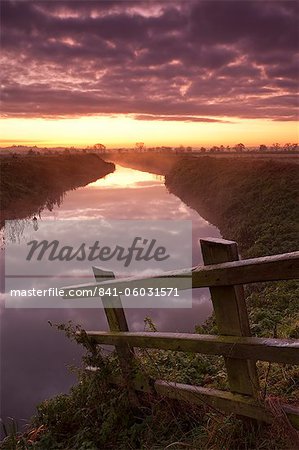 Lever du soleil sur le Brue River près de Glastonbury, Somerset Levels, Somerset, Angleterre, Royaume-Uni, Europe