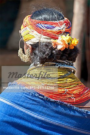 Bonda tribeswoman wearing blue cotton shawl over traditional bead costume, with beaded cap, large earrings and metal necklaces, Rayagader, Orissa, India, Asia