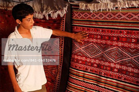 Junge zeigt einen Teppich in einem Teppich Shop, Toujane, Tunesien, Nordafrika, Afrika