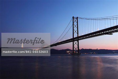 Le 25 avril pont suspendu au crépuscule sur le fleuve Tage (Rio Tejo), Christus Rei est illuminé à Almada, Lisbonne, Portugal, Europe