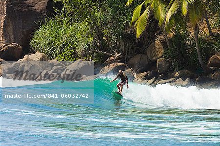 Surfer Reiten einer Welle in den westlichen Zipfel der Südküste Strand von Mirissa, in der Nähe von Matara, Südprovinz in Sri Lanka, Asien