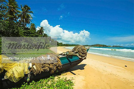 Outrigger fishing boat and nets at this quiet south coast retreat beach, Talalla, near Matara, Southern Province, Sri Lanka, Asia