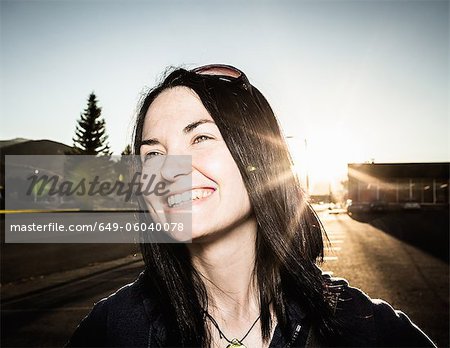 Femme souriante et du soleil à l'extérieur de flare