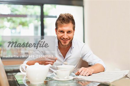 Souriant petit-déjeuner homme manger à table Souriant petit-déjeuner homme manger à table