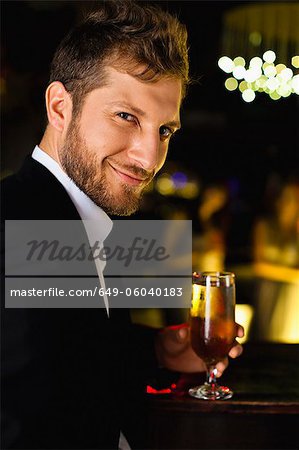 Smiling man having drink at bar