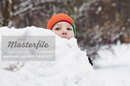 Garçon jouant dans la neige dans le parc