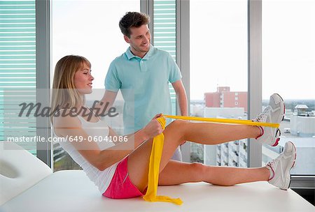 Doctor examining womans legs in office