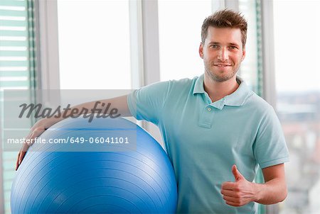 Mann mit gymnastikball im Fitness-Studio