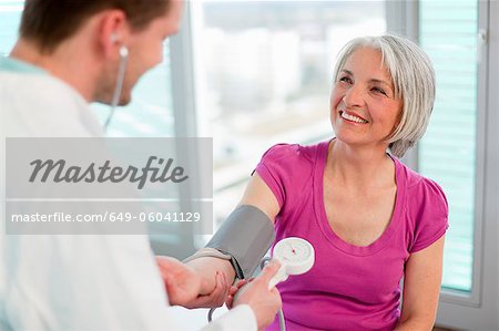 Doctor taking womans blood pressure
