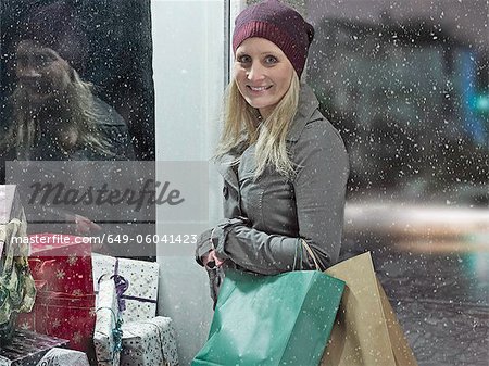 Femme portant des sacs à provisions dans la neige