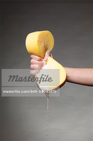 Main serrant une éponge savonneuse